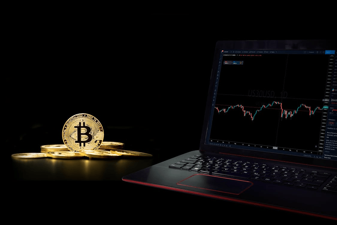 Laptop with gold coins on a desk, symbolizing Block