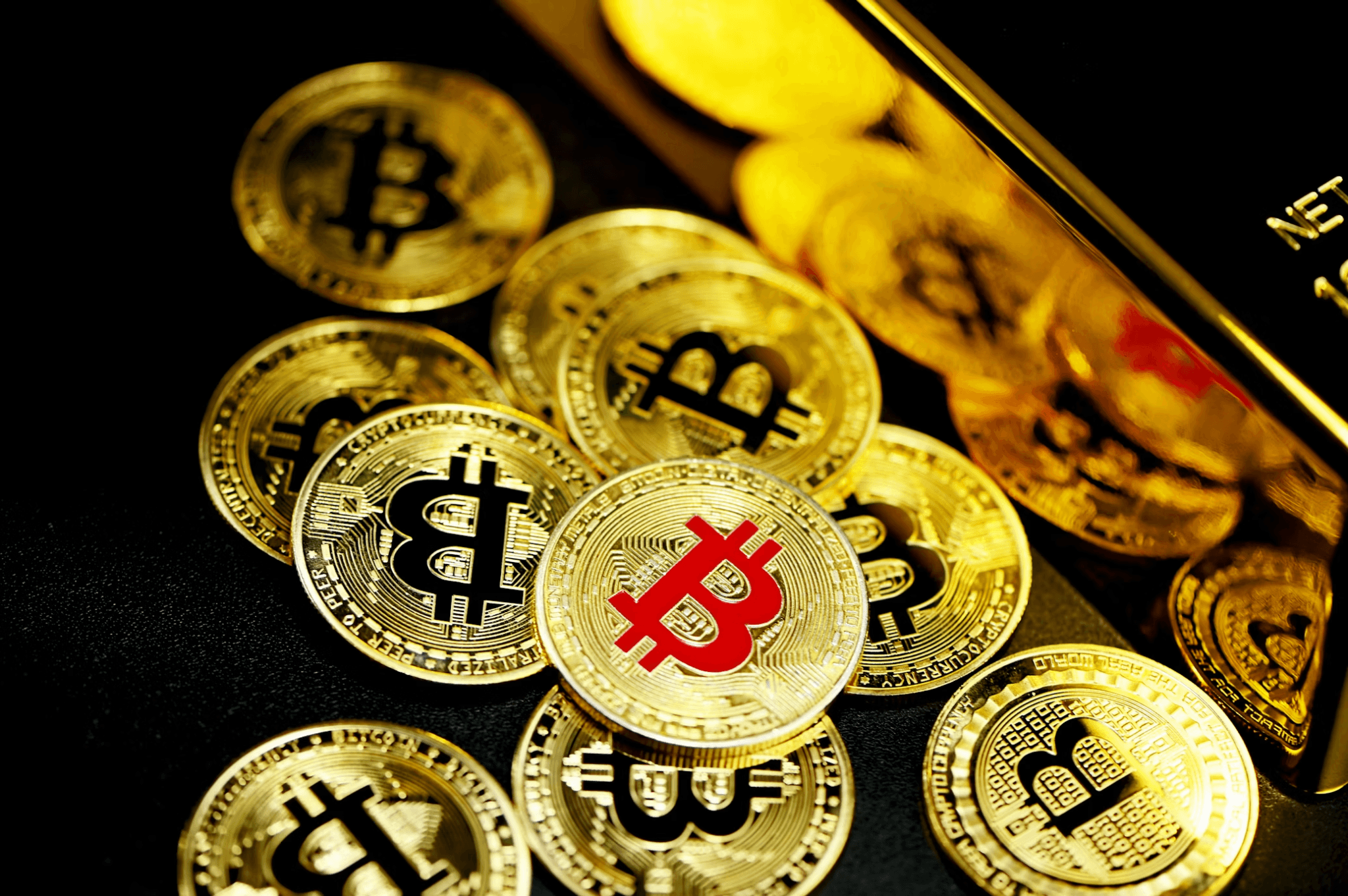 Pile of gold bitcoins with a cryptocurrency wallet